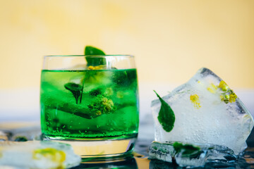 Green cocktail with mint, ice and soda.