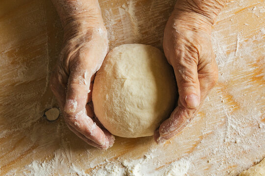 Cooking at home, old woman's hands kneading dough