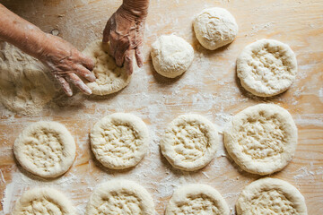 Cooking at home, old woman's hands getting the bread ready to be baked