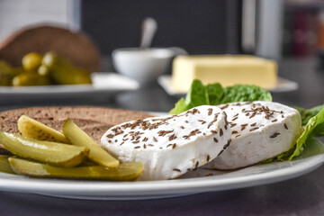 Deutscher Sauermilch Käse mit Gewürzgurken und Brot auf einen Teller