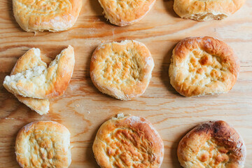 Cooking at home, rows of fresh tasty flatbreads on a wooden table