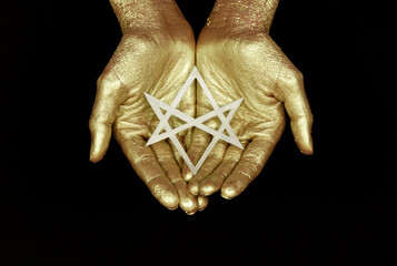 Golden hands on black background with six pointed star Unicursal hexagram.