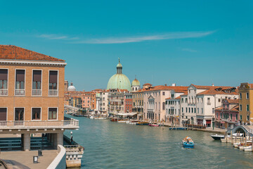 Fototapeta na wymiar Grand canal in Venice, with big green dome in the distance on a sunny summer day
