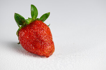 Ripe and juicy strawberry berries with drops of water on white.