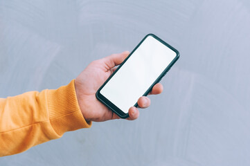 Mock-up technology. Man holds a smartphone in his hands close-up.