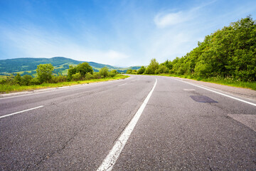 Empty asphalt road and summer landscape with green trees