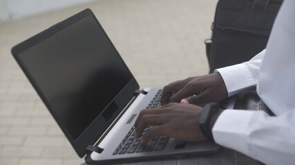 Close up of African American businessman working on laptop in park