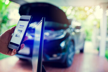 Scanning QR code payment with blurry cashier machine at counter service in car care service center.