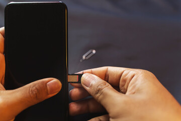 Employees are changing the phone SIM card, nano SIM card in the shop for customers to buy, Man's hand.