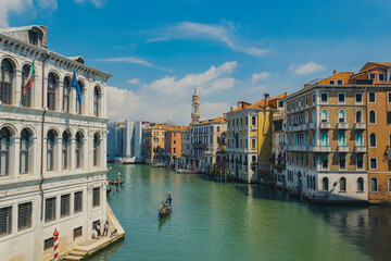 Grand canal in Venice, Italy, with gondolier on a gondola and ancient buildings on a beautiful sunny day