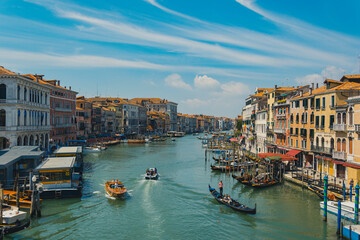 Grand canal in venice italy, with traffic of boats and gondolas and colorful and ancient buildings, typical view of the city