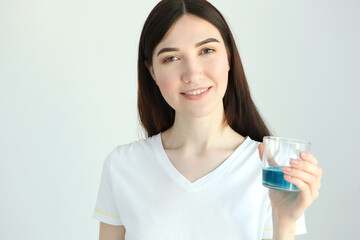 young girl uses mouthwash at home
