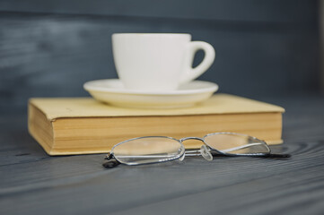 Concept on the topic of education. Books on a wooden background with coffee and glasses.
