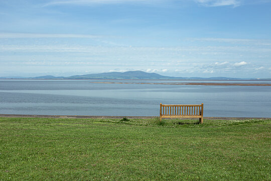 A bench looking over Silloth beach on a warm day.