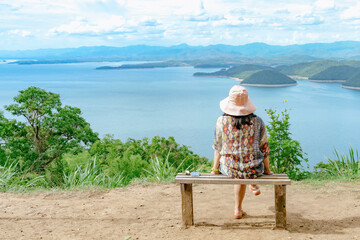 Back view of woman enjoy with beautiful scenery view of nature with a large reservoir above the...