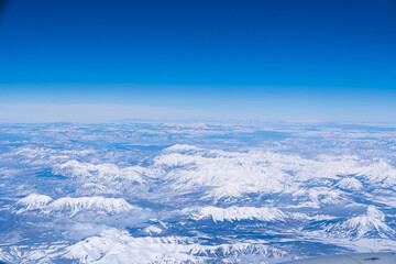 Obraz premium a landscape view from an airplane of snow-capped rocky mountains