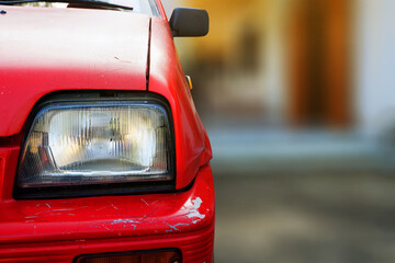 Fototapeta premium close up of front view of red old car was in front of the house