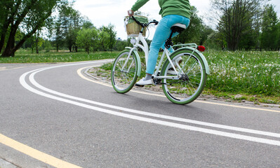 Naklejka premium Woman riding a bike on bike path with markings in park