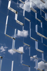 a modern glass building that reflects the sky