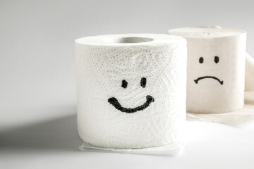 Toilet paper rolls with happy and sad smiles