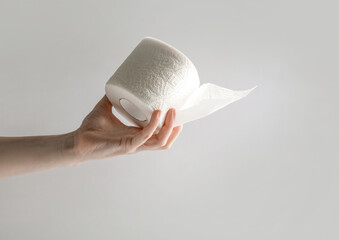 Hand holding toilet paper roll