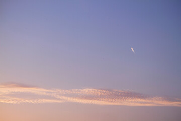 airplane in pink blue sky at sunset on a summer day