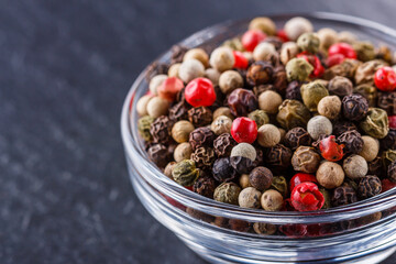 mix of peppercorns on a dark stone background