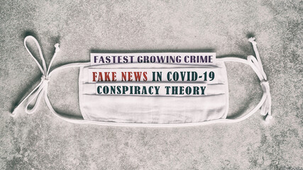 Beautiful medical background about lies. Text "Fastest growing crime. Fake news in Covid-19. Conspiracy theory." on a white gauze mask on a light gray background.