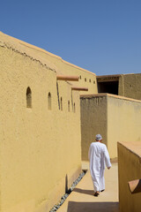 Man walking through the fort of Bahla, Oman.