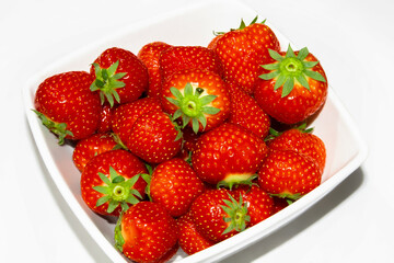 Strawberries in a plate. Strawberries on a white background.