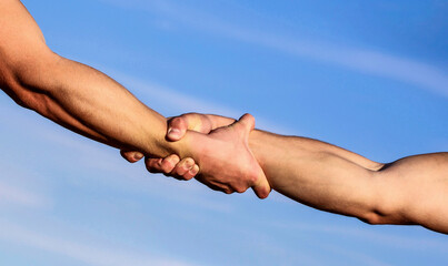 Hands of on blue sky background. Helping hand concept and international day of peace, support. Two...