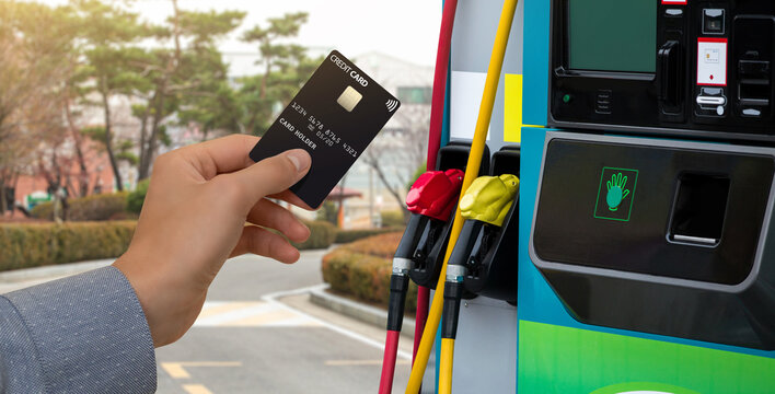 Hand With A Credit Card On The Background Of A Self-service Gas Station. Contactless NFC Payment 