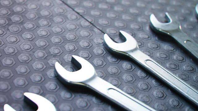 Chrome open-end wrench set arranged diagonally on textured mat