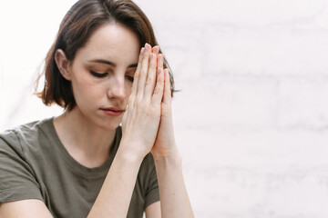Cute beautiful girl folded her hands in prayer. A woman asks God for help