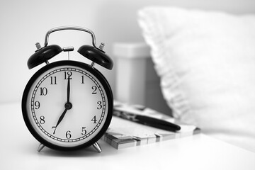 Alarm clock on table with notebooks and  pen. Wake up concept. An image of alarm clock showing...