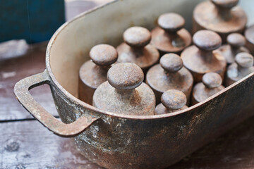 Old cast iron weights for scale in a cast iron bowl