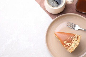 Piece of delicious cake with caramel served on light table, flat lay. Space for text