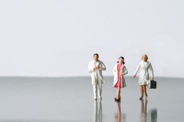 Front view of doctors and nurses walking out to work. Miniature people conceptual photography.