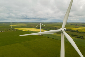 Aerial view of wind turbines in field on cloudy day