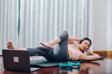 Obraz premium Młoda kobieta Azji usiąść do ćwiczeń mięśni brzucha na macie do jogi ze sprzętem do treningu sportowego. styl życia dla lepszego zdrowia. zostań w domu, aby zachować dystans społeczny, aby zapobiec chorobie koronawirusa