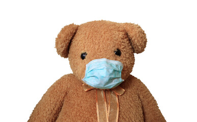Close up of Big brown bear toy with hygienic green mask sit alone on white isolated background with clipping path, Sick concept.