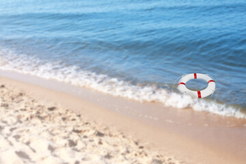 Fototapeta na wymiar Summer water safety. Life buoy floating in blue sea
