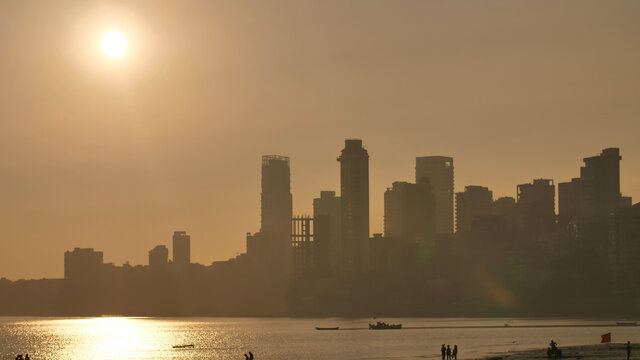Sunset on the background of Mumbai skyscrapers. View from Chowpatty Beach.