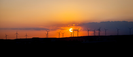 Wind generators at sunset. Panoramic view.