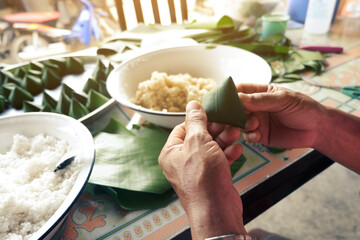 man and woman are confederate to Wrapped in local sweets with banana leaf   In occasion of Family Day and Songkran Festival of Thailand