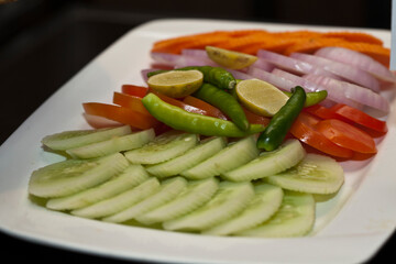 vegetable salad containing cucumber onion and tomato on white plate