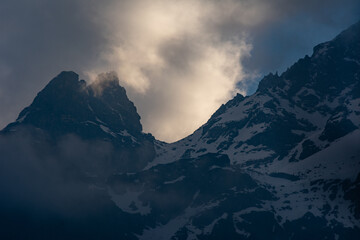 Fototapeta na wymiar mountain peak and yellowish clouds in the morning 