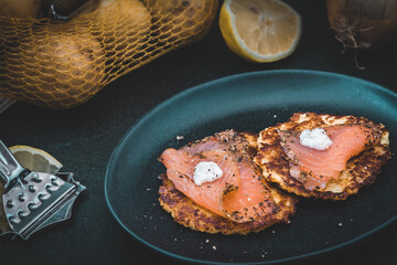 Potato pancakes with smoked salmon on dark background