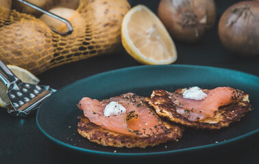 Potato pancakes with smoked salmon on dark background