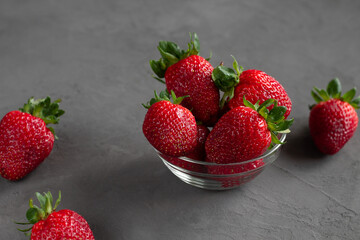 Strawberries in a bowl on a gray background